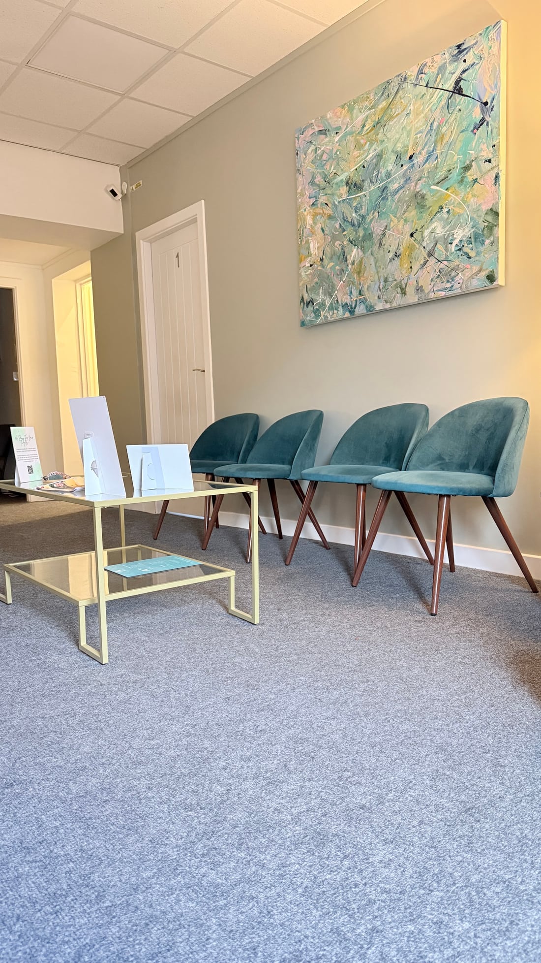 A comfortable waiting area with soft teal chairs at the Town Street premises